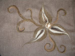 filcowy kwiat na szarym materiale.