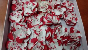 pudełko wypełnione dużą ilością czerwonych i białych kwiatów.