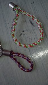 czerwono-biało-zielona smycz z metalowym haczykiem.