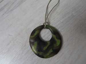 zielony naszyjnik leżący na drewnianym stole.