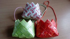 trzy kosze origami na drewnianym stole.