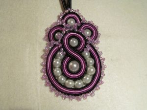 fioletowy naszyjnik z koralików na czarnym sznurku.