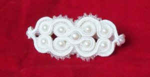 biała ozdoba na czerwonym tle.