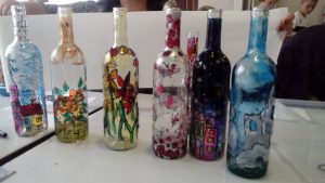 grupa szklanych ozdobionych butelek leżących na stole.