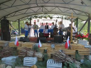 grupa mężczyzn ubranych na ludowo stojących na scenie.