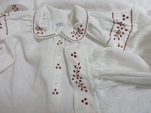 białą koszulę z czerwonym wzorem.