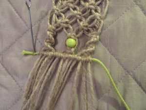 zbliżenie szydełkowanej szmatki z szydełkiem.