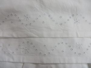 zbliżenie białego materiału z białymi kwiatami.