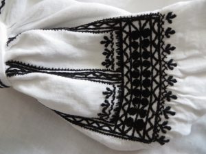 białą koszulę z czarnym wzorem.