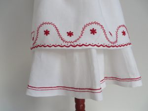 biała sukienka z czerwonym haftem.