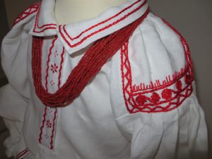 zbliżenie białej koszuli z czerwonym wykończeniem.