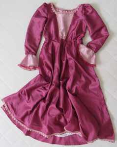 różowa sukienka leży na białej powierzchni.