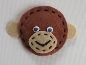 zbliżenie głowy małpy zrobionej z filcu.