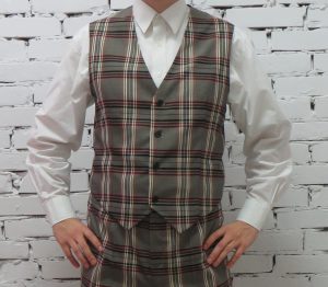 mężczyzna stojący przed białą ścianą z cegły.