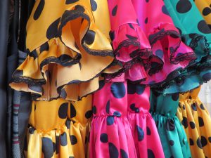 grupa kolorowych sukienek wiszących na wieszaku.