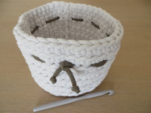 szydełkowana osłonka na doniczkę w kolorze białym.