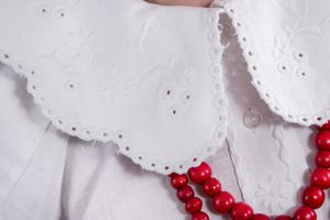 zbliżenie osoby noszącej czerwone korale.