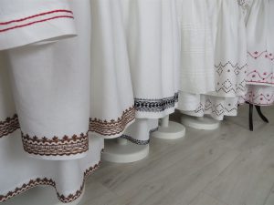 rząd białych strojów z kolorowymi haftami